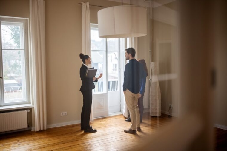 Eine Maklerin zeigt zwei Interessenten eine leerstehende Wohnung.