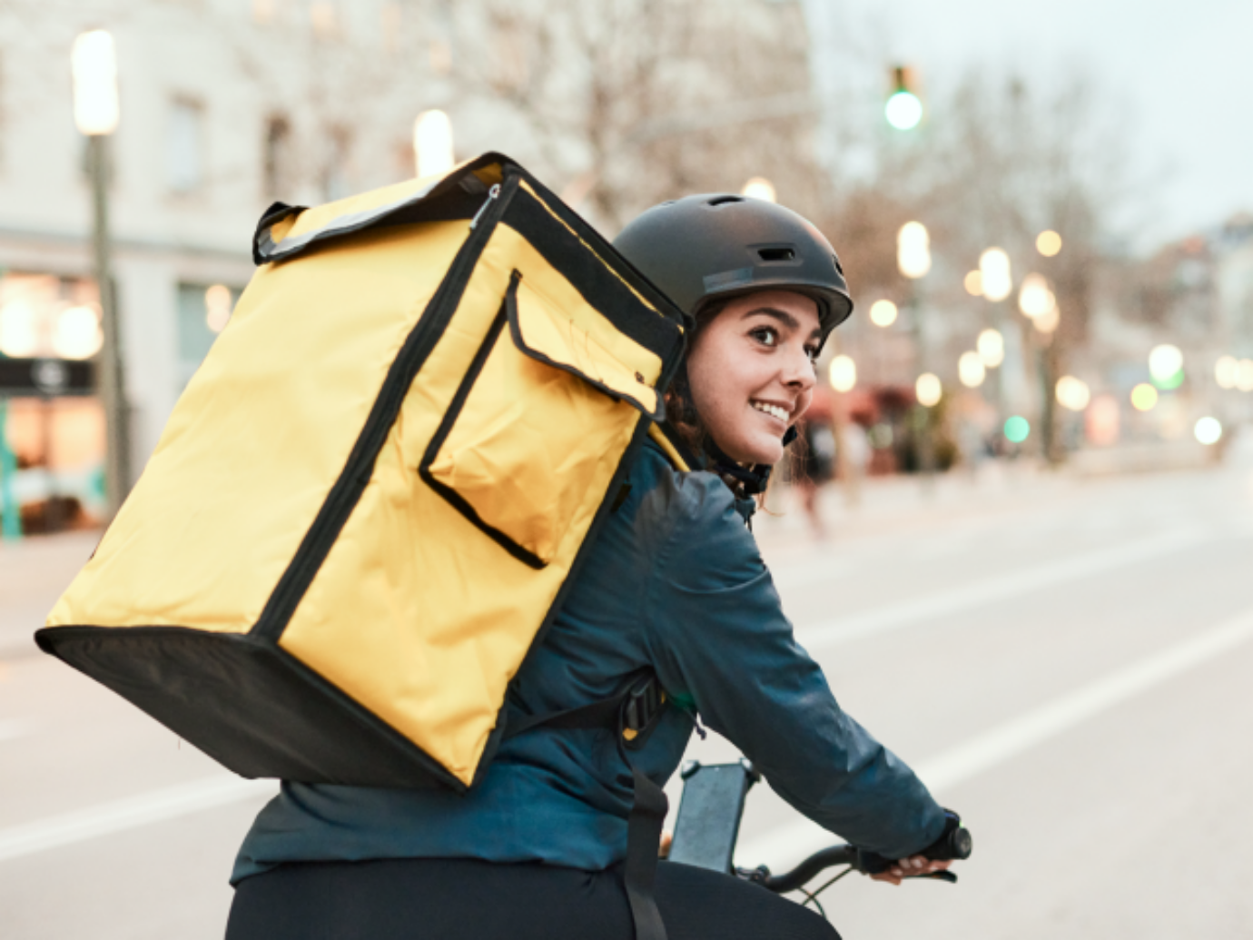 Eine junge Fahrerin ist mit ihrem Fahrrad im Stadtverkehr unterwegs.