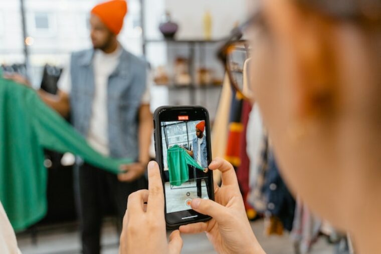 Mit Flohmarkt-Apps kannst du mit alten Sachen Geld verdienen. Auf dem Bild fotografiert eine Person Kleidung, um sie anschließend per App zu verkaufen.