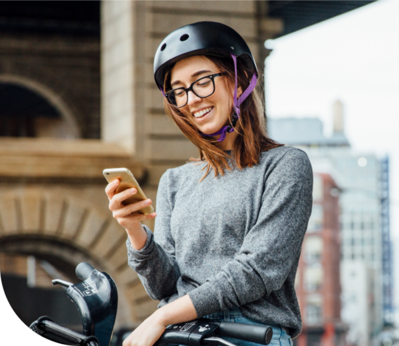 Eine junge Frau sitzt auf ihrem Fahrrad. Sie liest sich auf ihrem Handy die Voraussetzungen durch, um bei Zenjob zu arbeiten.