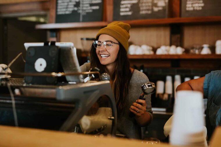 Frau arbeitet an der Kaffeemaschine