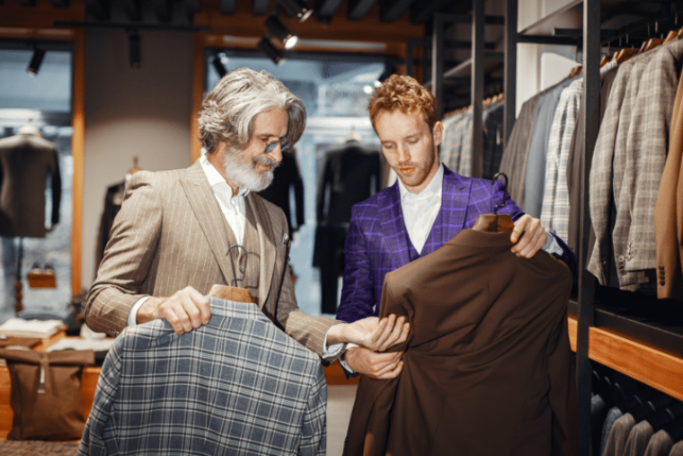 Personalplanung im Retail. Im Bild zeigt ein Mitarbeiter einem Kunden einen Blazer.