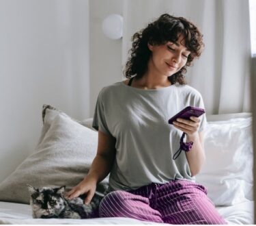 Zenjob App_ Frau sucht nach Nebenjobs vom Bett aus