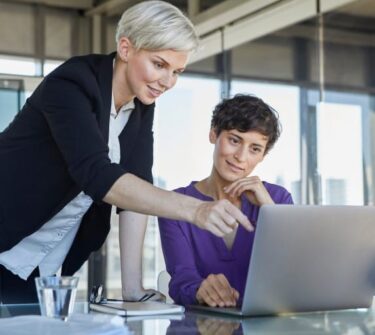 Zwei Frauen im Büro schauen auf den Laptop