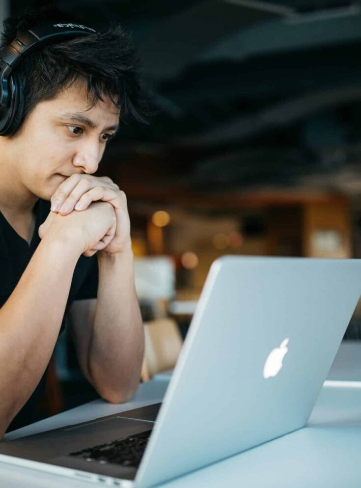 Student sitzt nachdenklich vor dem Laptop