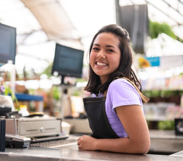 Student beim kassieren im Supermarkt