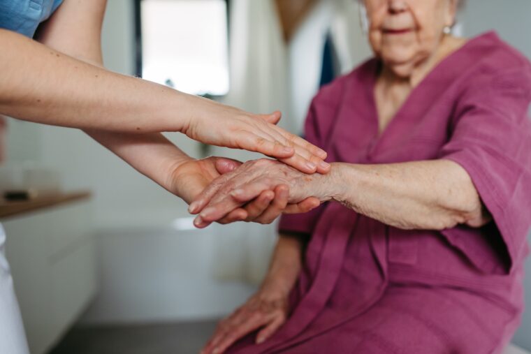 Pflegerin hält Hand einer Patientin