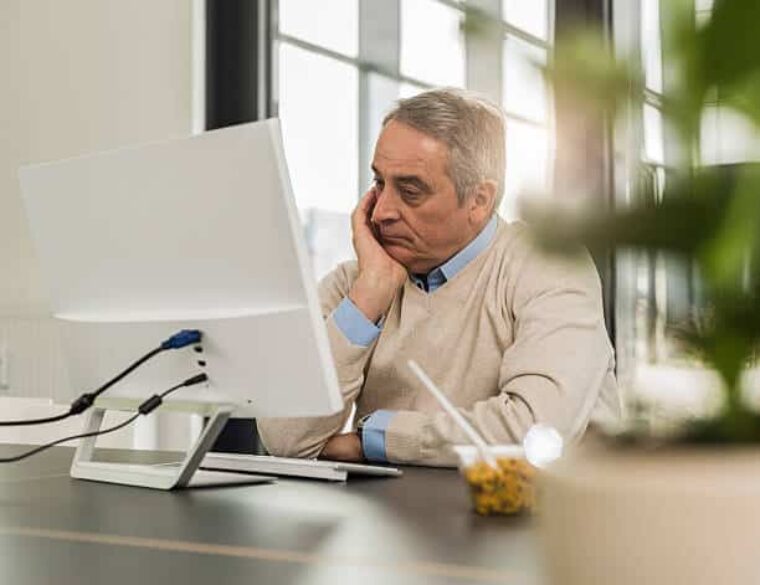Mann ist verzweifelt vor dem Laptop