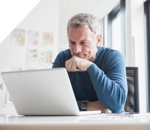 Ein Mann schaut auf einen Laptop