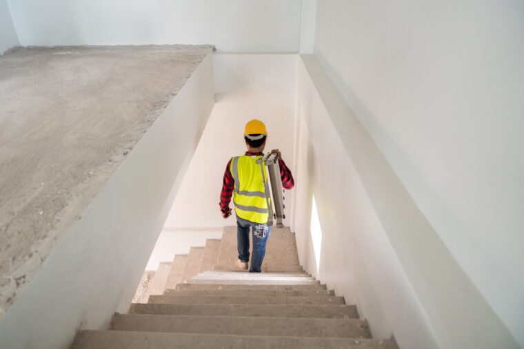 Mann läuft eine Treppe auf der Baustelle herunter