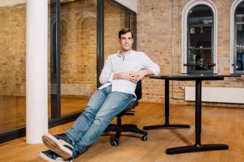 Co-Founder und CEO von Zenjob Fritz Trott sitzt auf einem Stuhl im Büro
