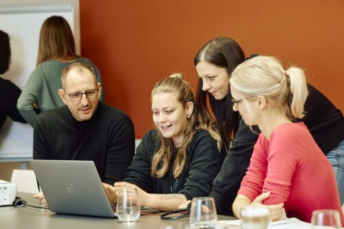 Teambesprechung bei KiM im Customer Suppot Team vor einem Laptop