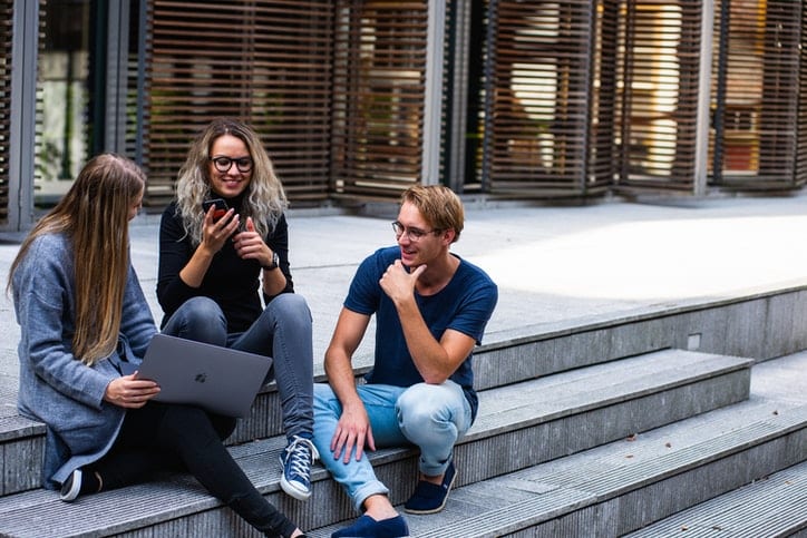 happy colleagues outside talking on stairs