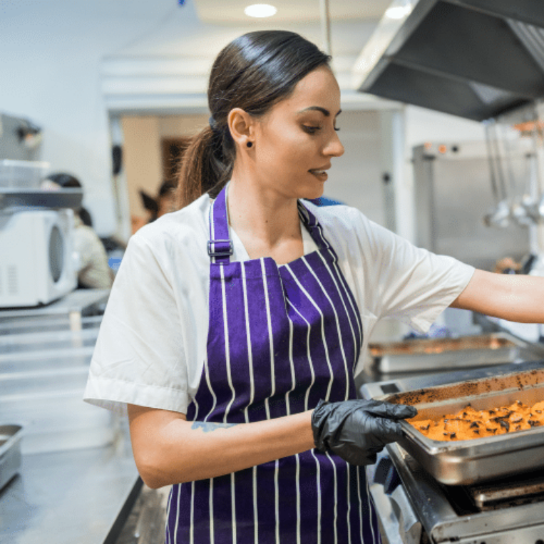 One of the more popular minijobs in the Zenjob app is working as a kitchen helper. The photo shows a young woman working in a kitchen.