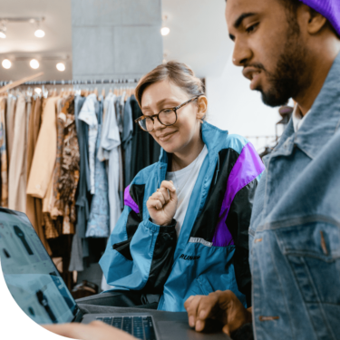 In the Zenjob app, you can find many student jobs in retail. The image shows a young man helping a female customer during his shift as store assistant.