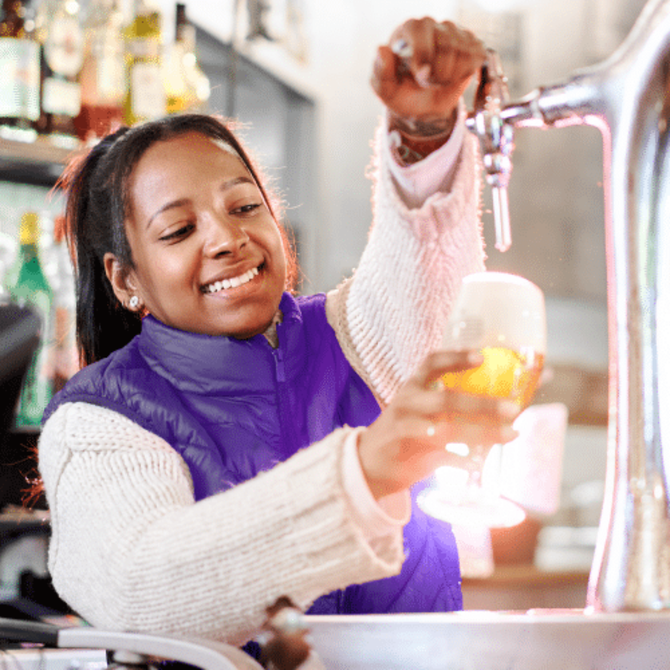 The image shows a young woman pour beer at an event. Summer jobs like this are very popular in the Zenjob app.