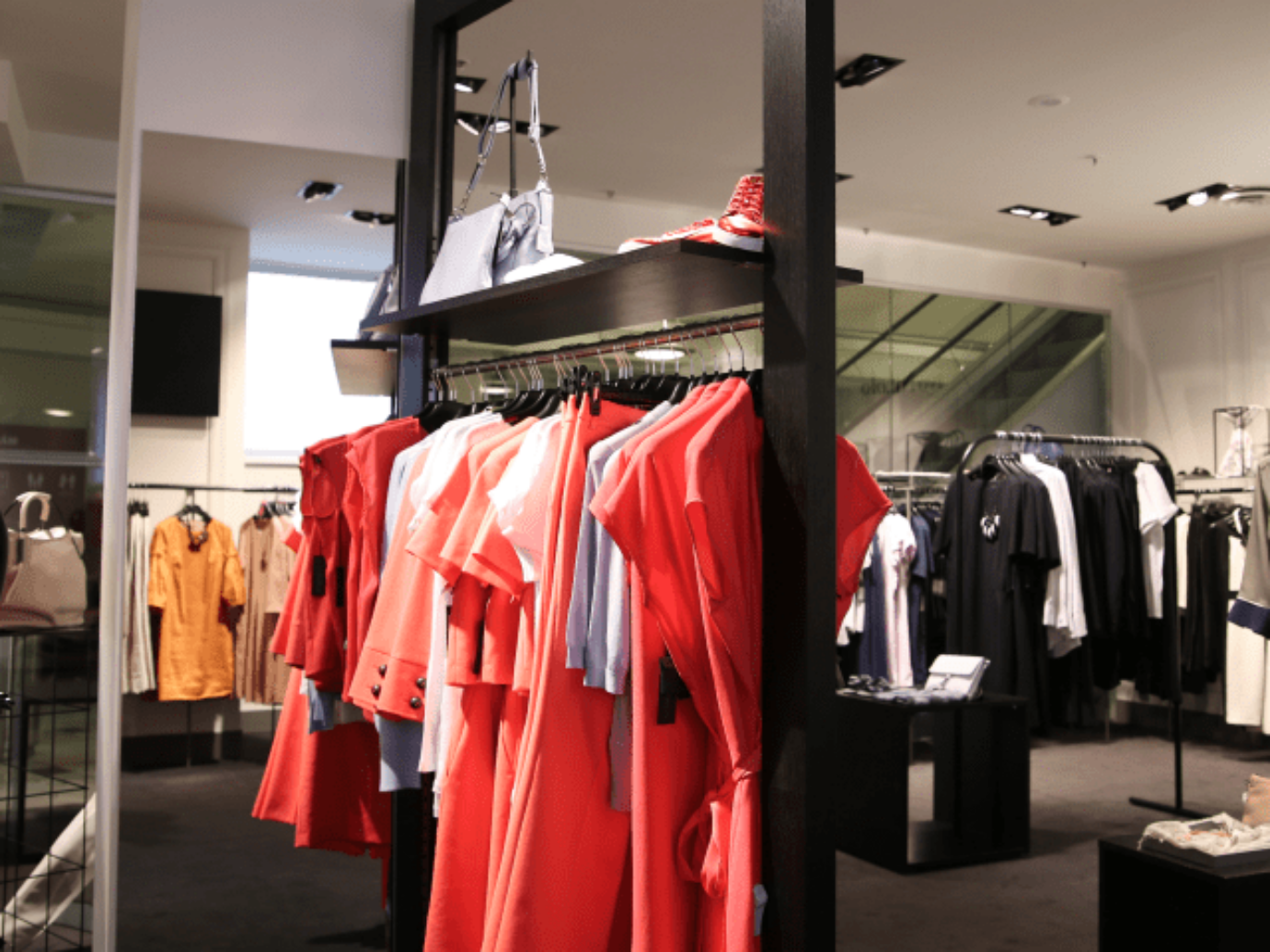 The image shows a clothing rack in an apparel store.