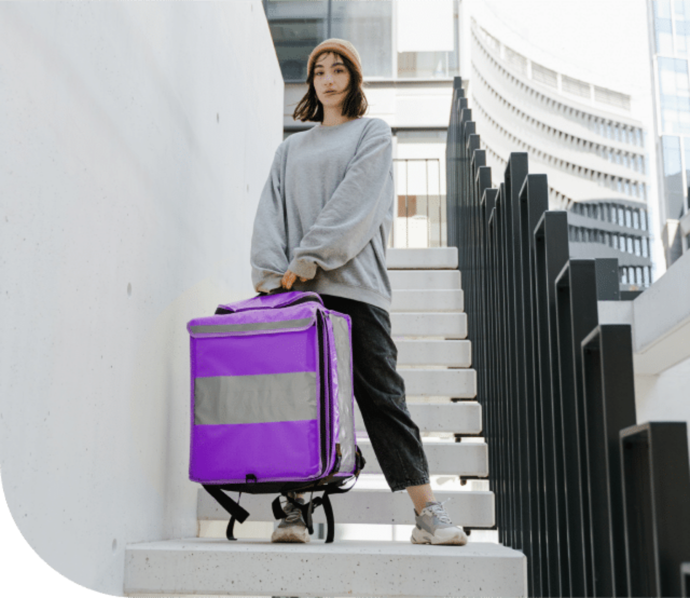 The image shows a young woman who is working as a courier for her first job at Zenjob.